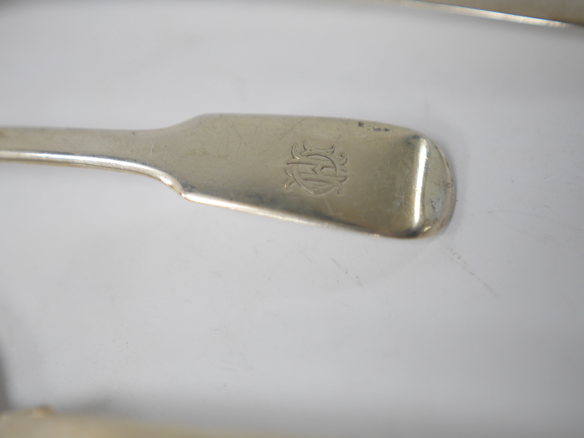 A late 19th century continental silver caddy spoon, with figural terminal, import marks for Sheffield, 1894, together with four assorted 19th century spoons including three table spoons and a sauce ladle, various dates a